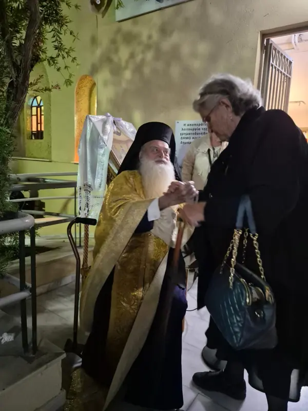 Ο ιερέας χαιρετά μια επισκέπτρια μετά την ακολουθία